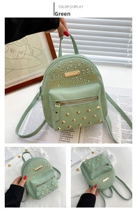 Detail view of a light green mini backpack with metallic rivets and earphone hole design