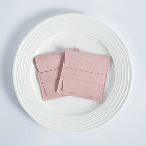 Detail of pink microfiber suede jewelry pouches with flap closure on a white plate