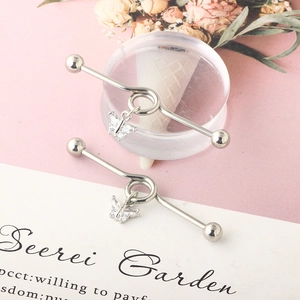 Detailed close-up of surgical steel industrial barbell with crystal butterfly pendants