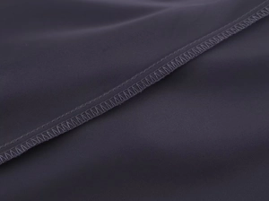 Vue macro détaillée du tissu satiné gris foncé montrant la précision des coutures
