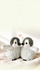 Nahaufnahme eines weichen Pinguin-Plüschtiers mit rosa Wangen auf weißem Plüschteppich