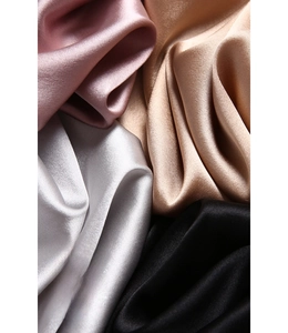 Close-up of silk face mask fabrics showing luxurious drape and shiny satin texture in four colors