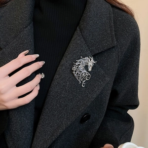 Detailed view of hollow filigree horse brooch with sparkling zircons on a coat lapel
