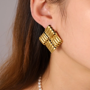 Golden 18K stainless steel square hoop earrings with textured stripes on a female model