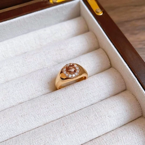 Macro view of gold plated tiger eye ring with zircon halo inside a premium jewelry box