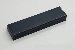 Detail of navy blue faux leather watch box featuring white decorative stitching