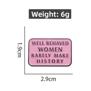 Detail of pink enamel brooch measuring 2.9cm by 1.9cm with feminist slogan