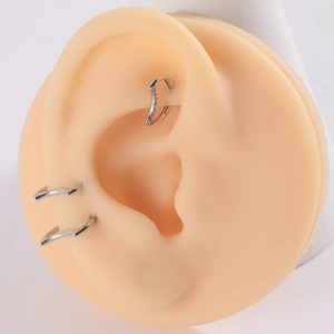 Close-up of G23 titanium nose stud with zircon on ear model for realistic look