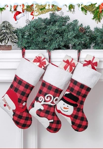 Three plaid Christmas stockings with Santa, reindeer, and snowman hanging on a white mantel