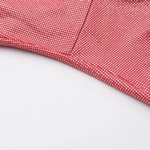 Detailaufnahme des roten elastischen Stoffes mit silbernen Metallpunkten am Kleid