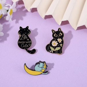 Detailed close-up of cute cat enamel pins with floral and crescent moon motifs on purple background