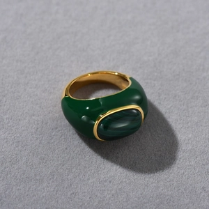 Macro shot of a 18k gold plated ring with malachite stone and deep green enamel finish