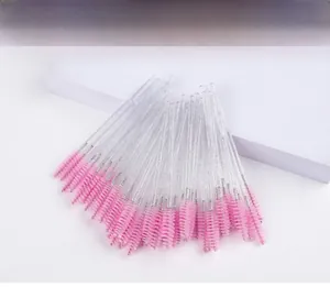 Detail of pink crystal lash brushes with glitter handles arranged on white display