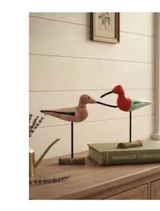 Detail of Nordic wooden painted bird ornaments with metal stands and rustic timber bases