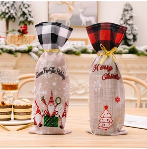 Close-up of Christmas gnome wine bottle bags with plaid trim and burlap texture for holiday decor