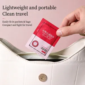 Portable stain removal wipe for clothes shown being placed in a white luxury handbag