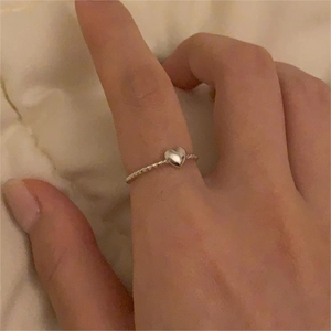 Detail of a minimalist S925 sterling silver heart open ring worn on a finger
