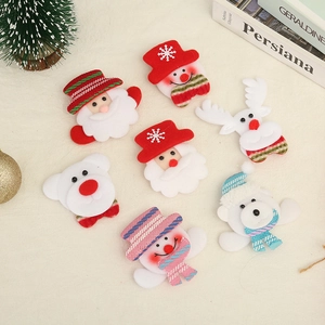 Flat lay of 7 assorted Christmas felt patches with Santa and deer on beige linen