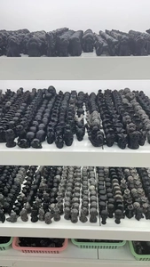 Detailed rows of matte black obsidian figurines featuring teddy dogs and skull sculptures