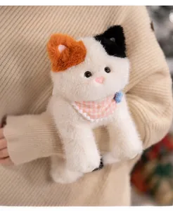 Detail of calico plush cat toy with long fur texture and pink checkered bib decoration