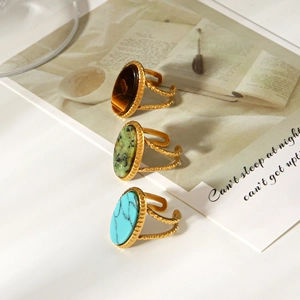 Detail shot of vintage gold rings with oval tiger eye and turquoise stone inlays