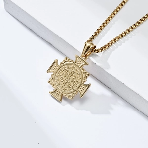 Gold St. Benedict exorcist cross necklace in stainless steel on white marble background