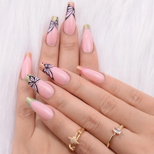Detail of pink long press-on nails with black butterfly patterns and gold glitter French tips