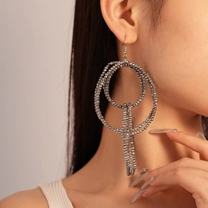 Detailed view of silver grey layered beaded hoop earrings with tassels on model
