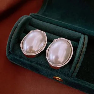 French vintage oval pearl earrings with silver frames on dark green velvet box