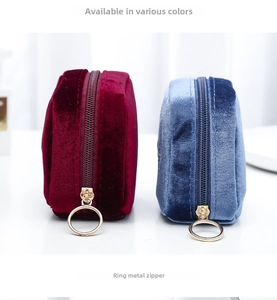 Detail view of velvet lipstick pouches in wine red and blue with gold ring zippers