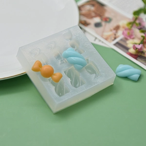 Detail of a 6-cavity silicone candy mold with orange and blue spiral-shaped treats