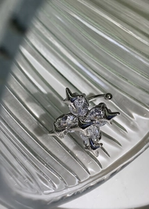 Detail shot of silver cross navel ring with marquise cubic zirconia on glass