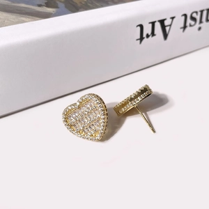Close-up of golden heart-shaped stud earrings featuring full pave square and round zircons