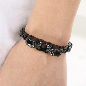 Détail du bracelet chaîne de moto tête de mort noire au poignet au style métal robuste