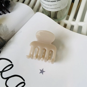 Minimalist beige shark hair claw clip in a sleek resin finish for elegant ponytails