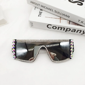 Détail de lunettes de soleil oversize avec strass multicolores et verres foncés