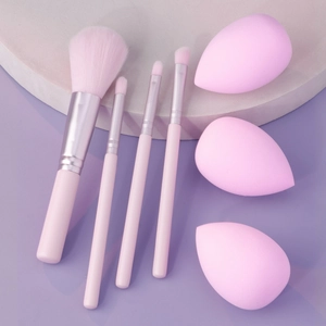 Pink makeup brush set with three blending sponges displayed on a pastel background
