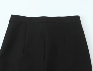 Close-up of the waistband tailoring and seam details on black high-waist stirrup pants