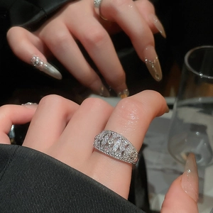 Macro view of wide sparkling zircon bow ring on model with mirror reflections