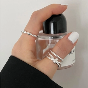 Detail of silver S925 knotted ring and beaded band worn by a model in a modern style