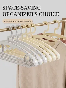 Close-up of non-slip curved hangers in beige and grey with a space-saving seamless design