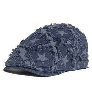 Détail du béret en denim bleu avec imprimés étoiles et bords effilochés vintage