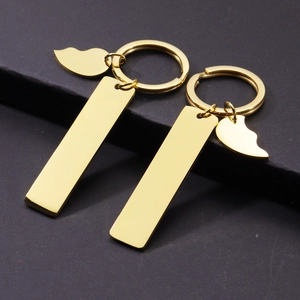Polished gold rectangular keychain set with heart and moon charms on dark background