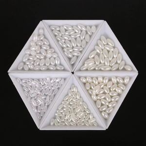 Detailed view of oval ABS imitation pearls in white shades for DIY jewelry making