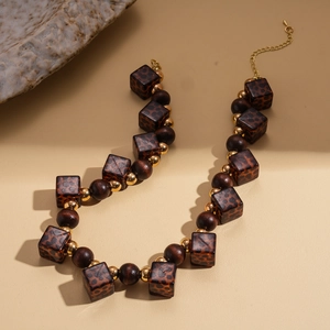 Detail of leopard print acrylic cubes and dark wood beads necklace with golden clasp