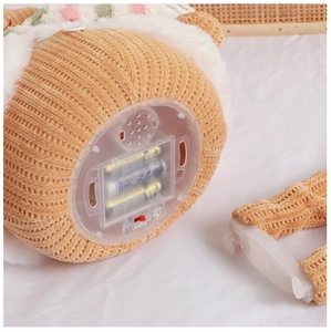 Macro detail showing the battery compartment and power switch of the gingerbread doll
