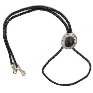 Detail of western bolo tie featuring silver floral engraving and black oval gemstone