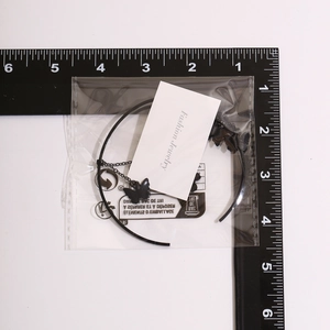 Macro view of gothic cross crystal chain arm cuff with butterfly pendant and scale ruler