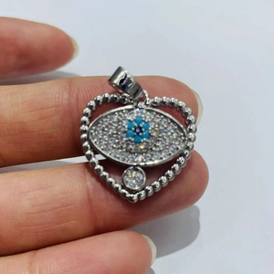 Detailansicht des herzförmigen Evil Eye Anhängers mit blauen Perlen und Strasssteinen