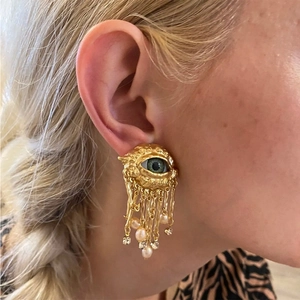 Golden Evil Eye dangle earrings with green eye charm, pearls and tassel chains on model